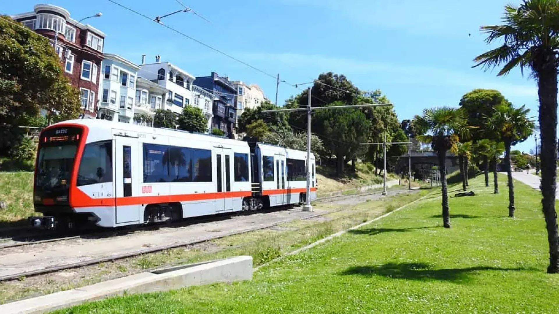 MUNI 旅客列車がサンフランシスコの線路に沿って走っています。