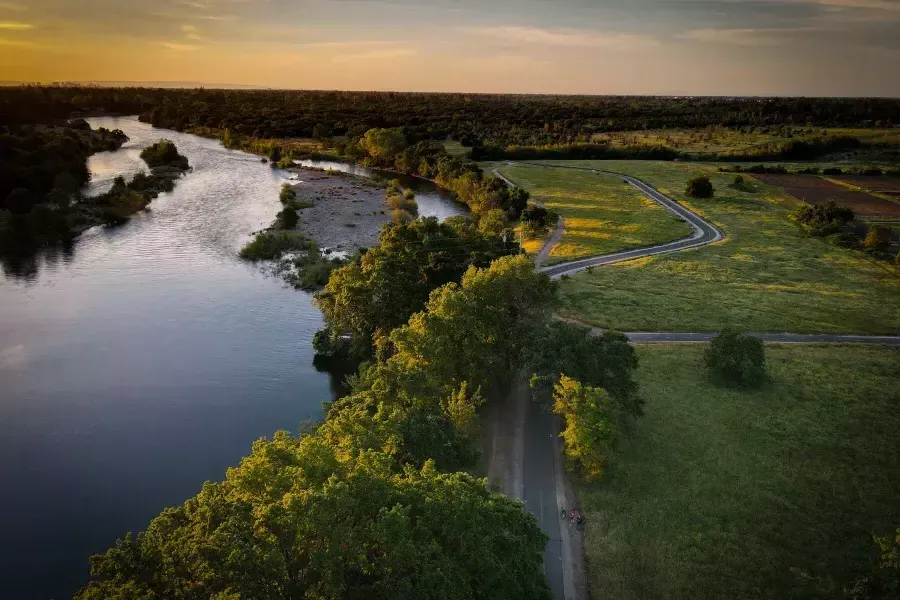 Image of green area and waterway next to it during sun set 