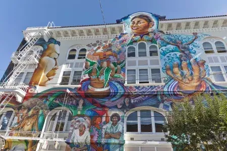 A colorful, large-scale mural covers the side of the Women's Building in San 弗朗西斯co's Mission District.